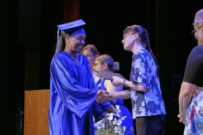 طالبة متخرجة تتسلم صورة شهادتها