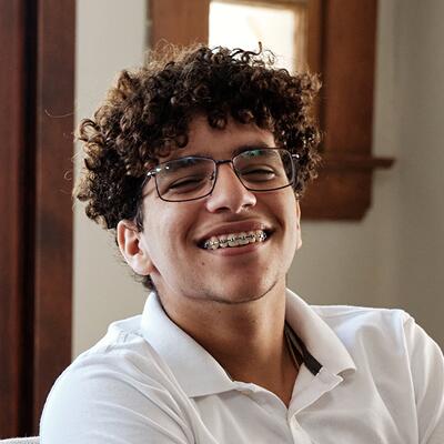 ماثيو، طالب، يرتدي نظارات وقميص بولو أبيض